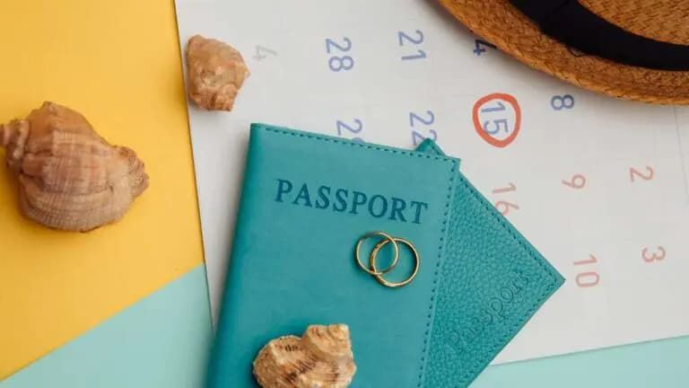 calendar-with-passports-hat-and-rings-on-colorful-surface-honeymoon-wedding-concept-date-of-travelling-1-768x432.jpg.jpg