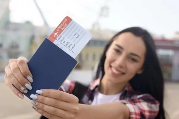 mujer-atractiva-feliz-mostrando-pasaporte-boleto-aereo-al-aire-libre-600x400.jpg.jpg